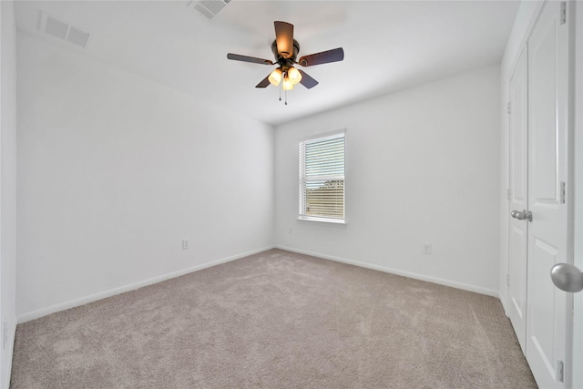 spare room with light colored carpet and ceiling fan