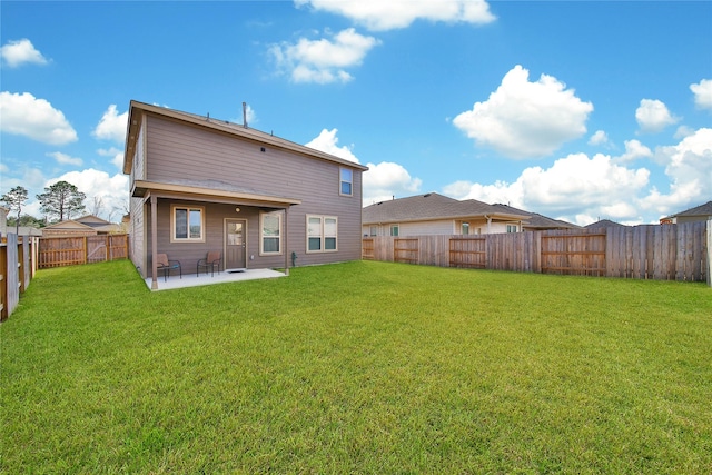 rear view of house with a patio and a lawn