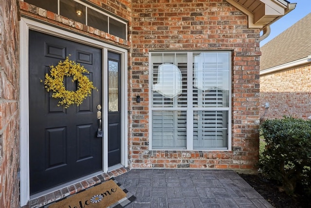 entrance to property featuring brick siding