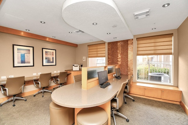 home office featuring built in desk, light colored carpet, a textured ceiling, and plenty of natural light