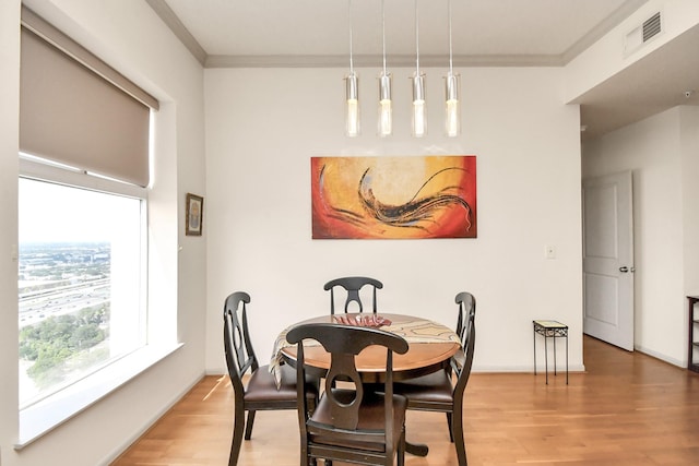 dining space featuring hardwood / wood-style flooring and ornamental molding