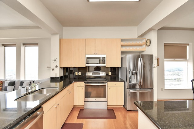 kitchen with stainless steel appliances, sink, light brown cabinets, and light wood-type flooring