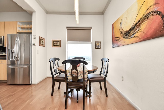 dining area featuring crown molding and light wood-type flooring