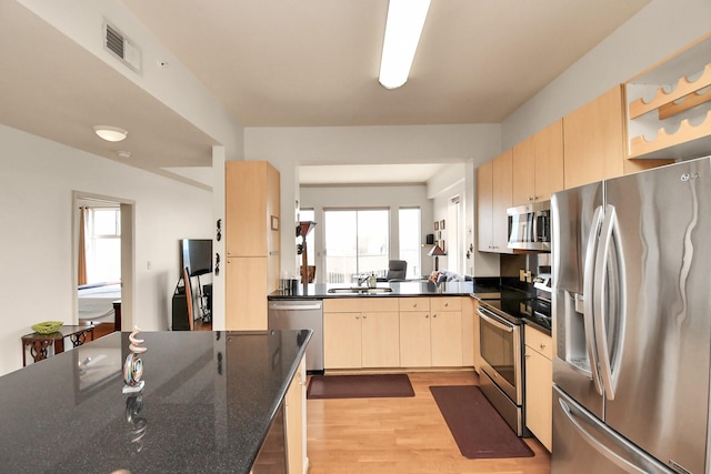 kitchen featuring light brown cabinetry, sink, stainless steel appliances, and light wood-type flooring