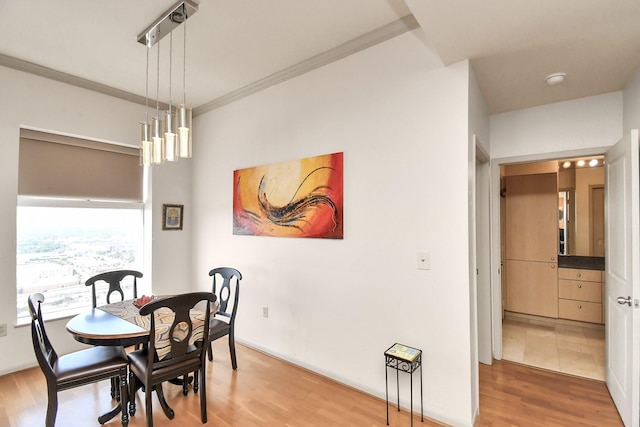 dining space featuring hardwood / wood-style flooring and crown molding