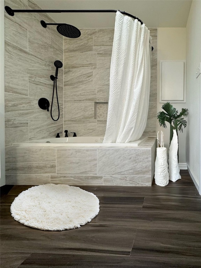 full bathroom featuring tiled shower / bath combo and baseboards