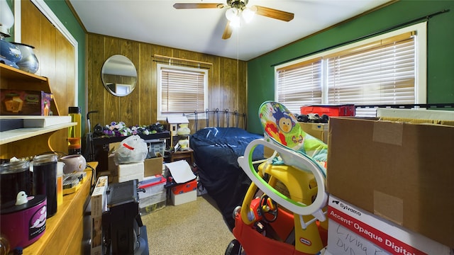 bedroom with multiple windows, ceiling fan, and wooden walls