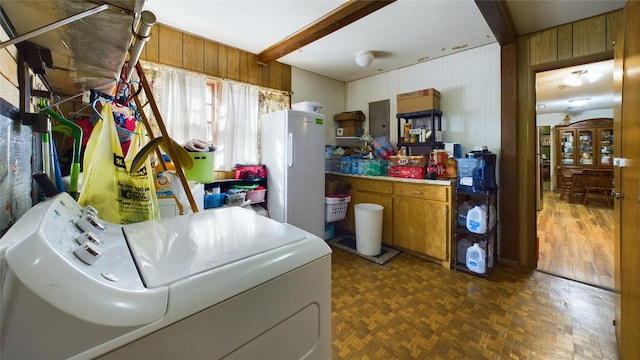 laundry area featuring washer / dryer, dark parquet flooring, and wood walls