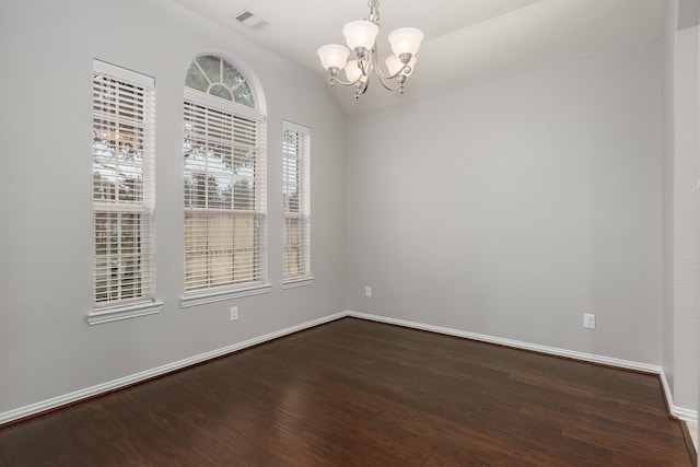 empty room with an inviting chandelier, lofted ceiling, and dark hardwood / wood-style floors