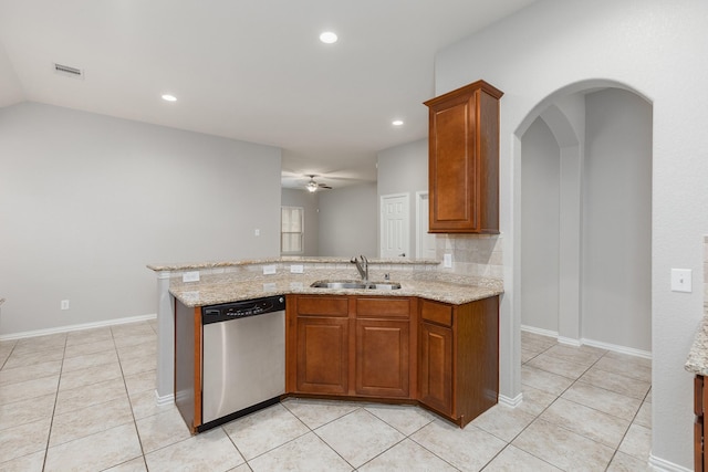 kitchen with sink, stainless steel dishwasher, light stone countertops, and light tile patterned flooring