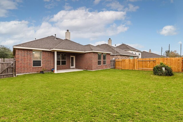 back of property with a yard and a patio area