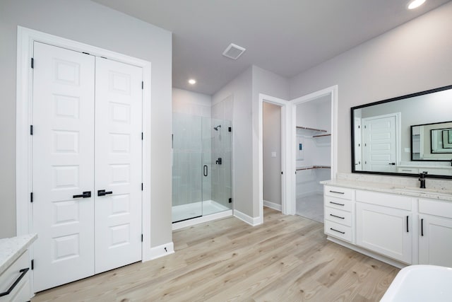 bathroom featuring vanity, a shower with shower door, and wood-type flooring