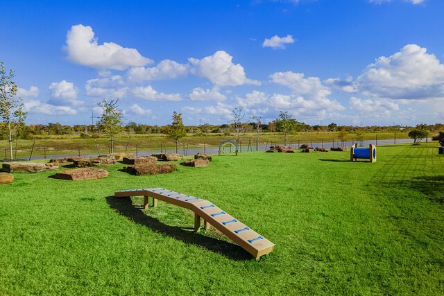 view of property's community featuring a rural view and a lawn