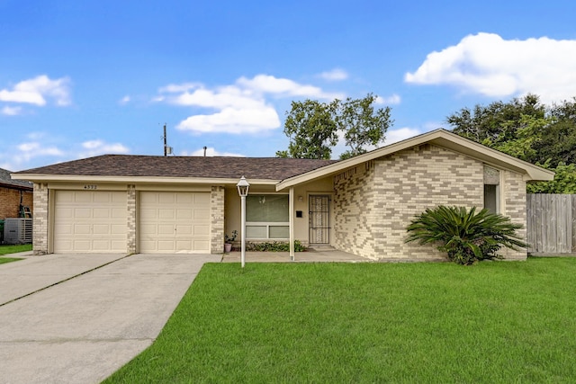 ranch-style house featuring a garage, a front lawn, and central air condition unit