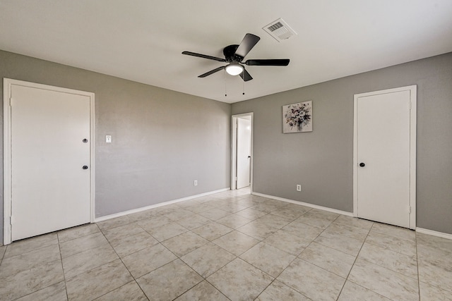 tiled spare room with ceiling fan