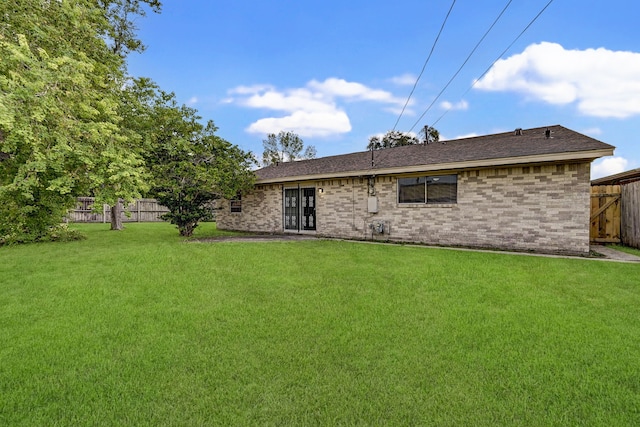 rear view of property with a lawn