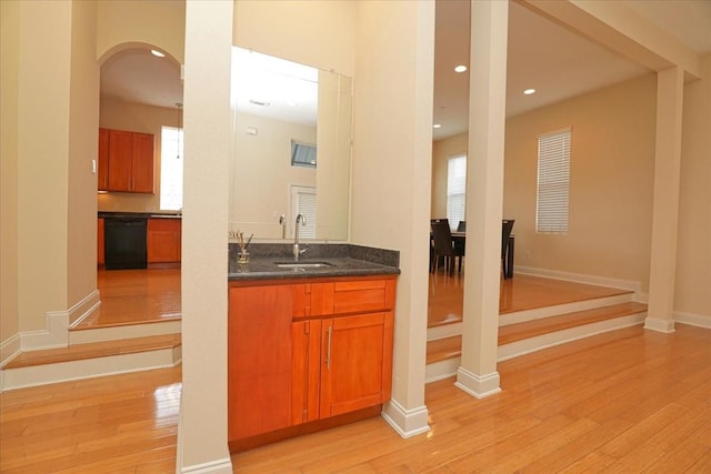 bar with dishwasher, sink, and light hardwood / wood-style flooring