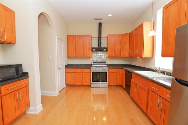 kitchen with sink, black appliances, pendant lighting, light hardwood / wood-style floors, and wall chimney range hood