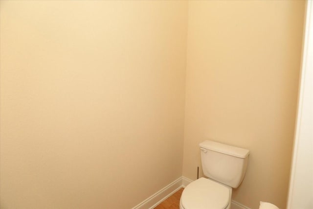 bathroom featuring wood-type flooring and toilet