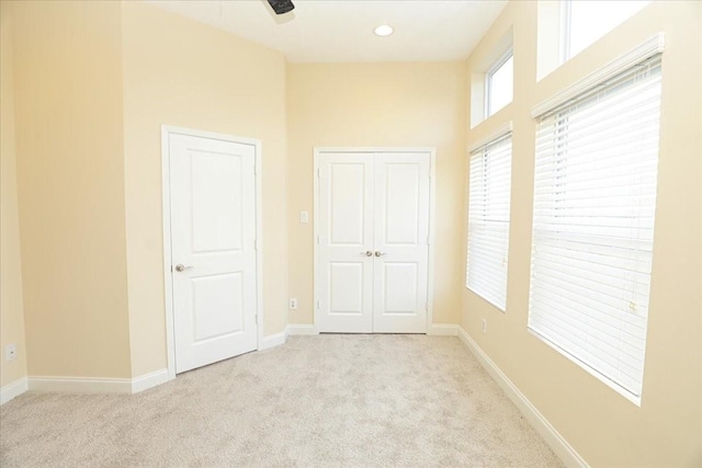 unfurnished bedroom featuring light carpet and a closet