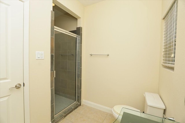 bathroom featuring tile patterned floors, toilet, and a shower with door