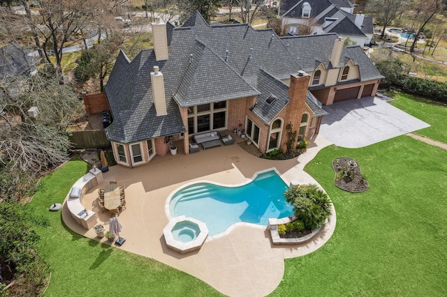 view of pool with an in ground hot tub, a patio, and a lawn