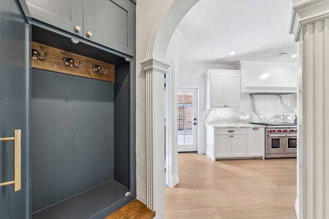 mudroom featuring crown molding, light wood-type flooring, and ornate columns