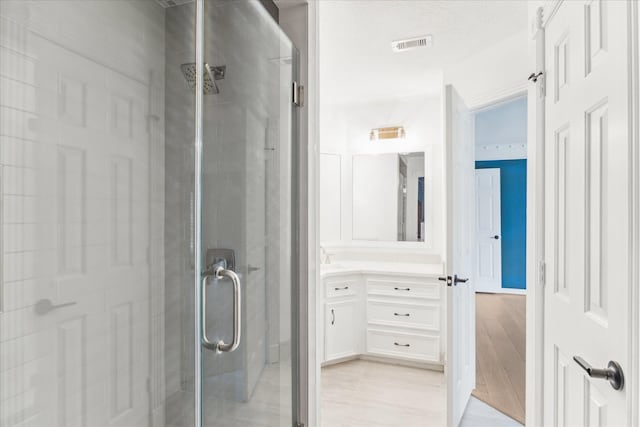 bathroom featuring walk in shower and vanity