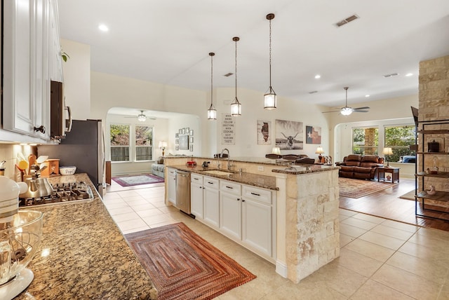 kitchen featuring pendant lighting, sink, appliances with stainless steel finishes, white cabinetry, and light stone countertops