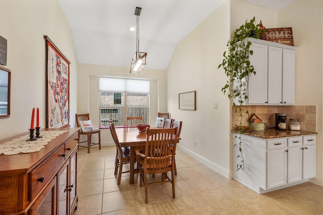 tiled dining space with vaulted ceiling