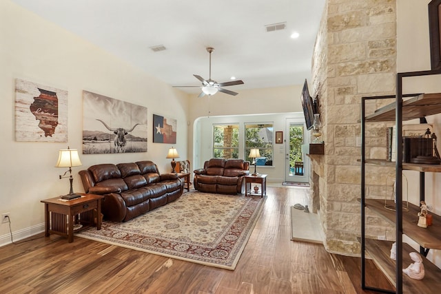 living room featuring a fireplace, wood-type flooring, and ceiling fan