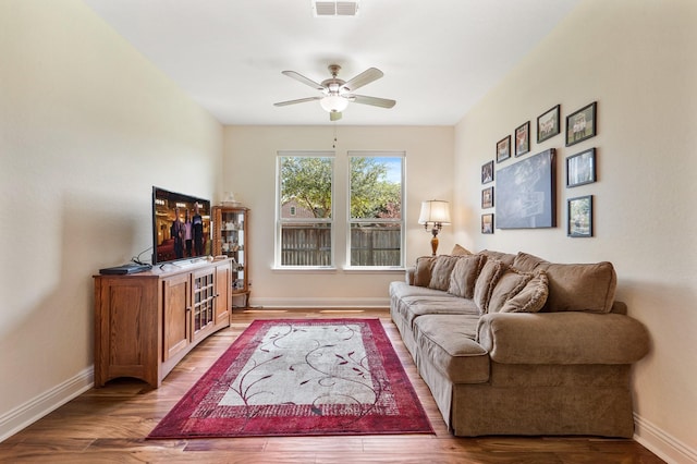 living room with wood-type flooring and ceiling fan