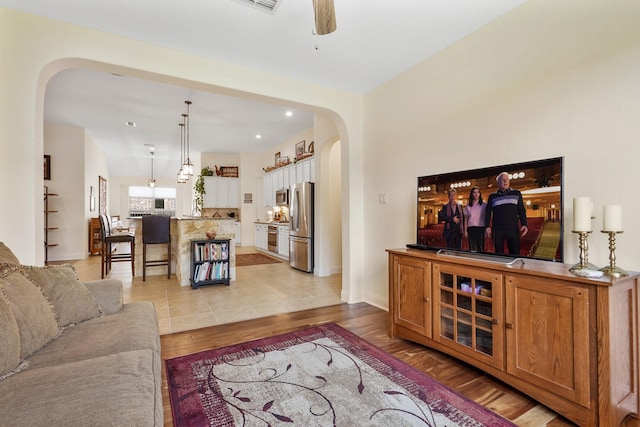 living room featuring ceiling fan and light wood-type flooring