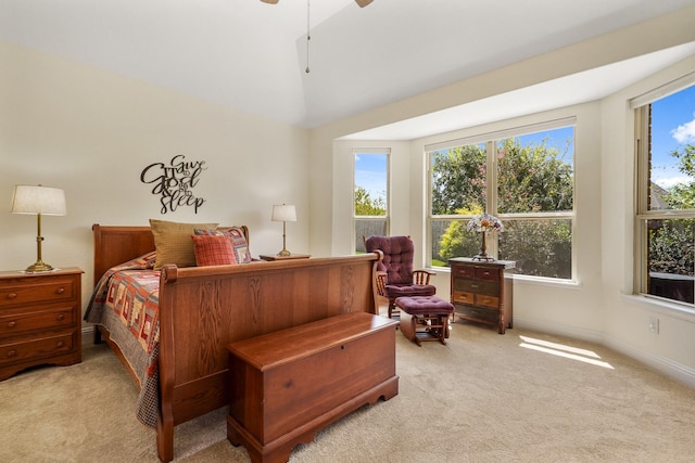 carpeted bedroom with multiple windows, vaulted ceiling, and ceiling fan