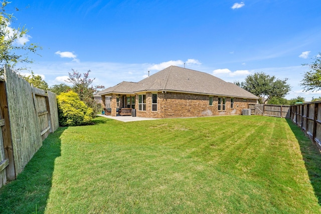 back of house with central AC, a yard, and a patio