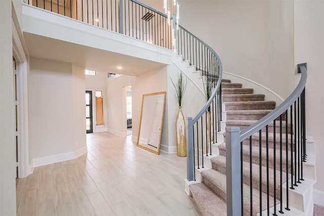 stairs featuring a high ceiling and wood-type flooring