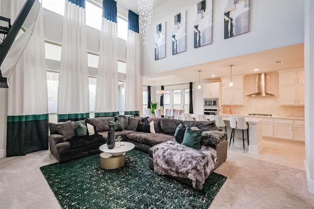 living room featuring light colored carpet, plenty of natural light, and a towering ceiling