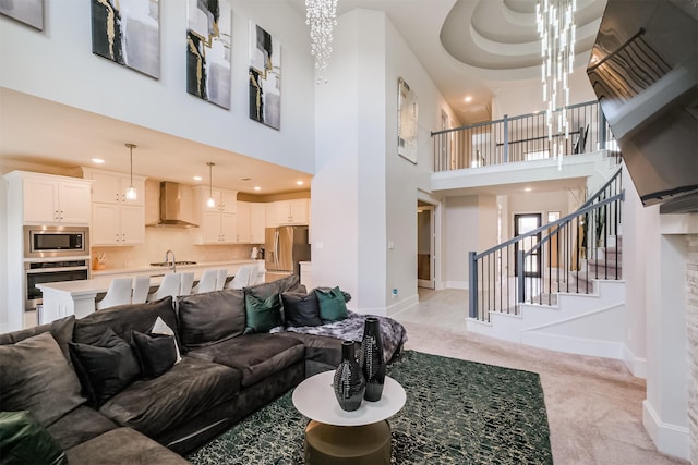 carpeted living room featuring sink and a towering ceiling