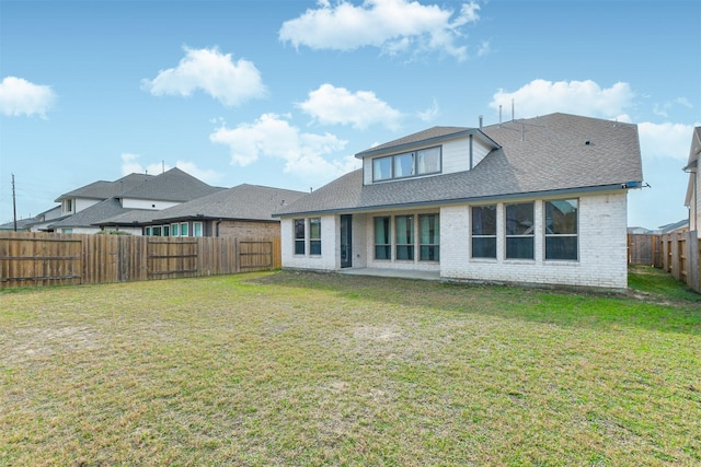 rear view of house featuring a yard