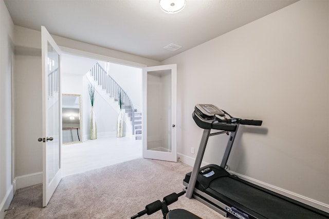 workout area featuring light carpet and french doors