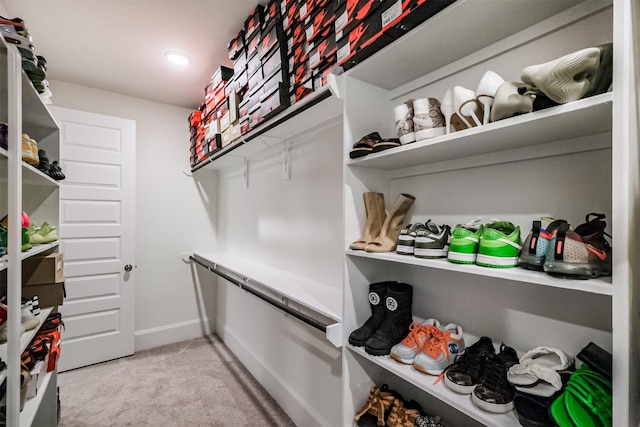 walk in closet with light colored carpet