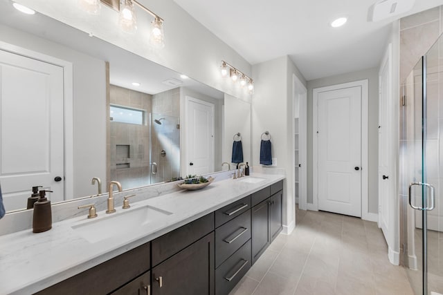 bathroom featuring tile patterned floors, vanity, and a shower with shower door