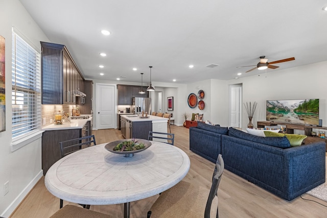 dining space with ceiling fan, light hardwood / wood-style flooring, and a healthy amount of sunlight