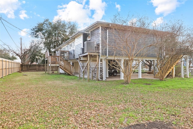 rear view of house with a wooden deck, central AC unit, a patio area, and a lawn