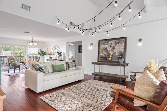 living room featuring an inviting chandelier, dark hardwood / wood-style floors, and rail lighting