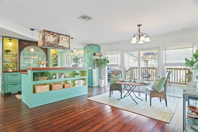 dining room with crown molding, dark hardwood / wood-style floors, and a chandelier