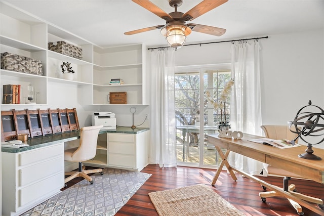 office with dark hardwood / wood-style floors, built in desk, and ceiling fan