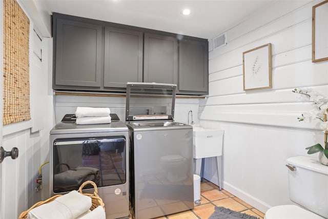 clothes washing area with light tile patterned floors and washer and dryer