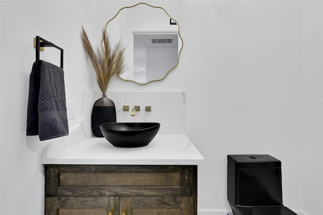 bathroom featuring visible vents, tasteful backsplash, and vanity