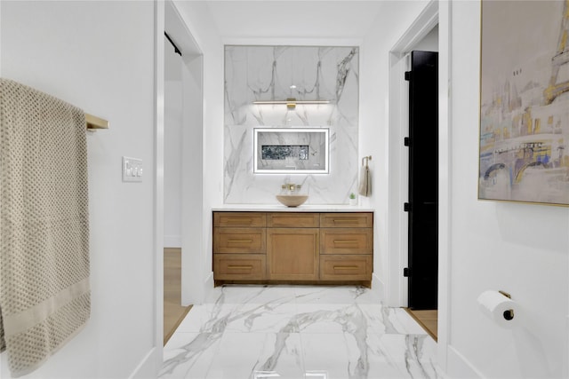 full bathroom with marble finish floor and vanity